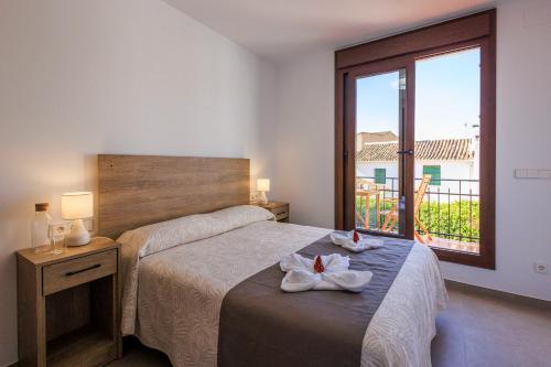 a bedroom with a bed with two towels on it at Apartamentos Turísticos Olivares in Mota del Cuervo