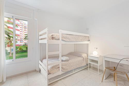 a bedroom with two bunk beds and a desk at Apartamento Sol Playa Torrox A55 in Torrox Costa