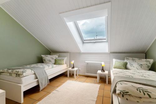 a attic room with two beds and a skylight at Ferienwohnung Sämann in Oberkirch