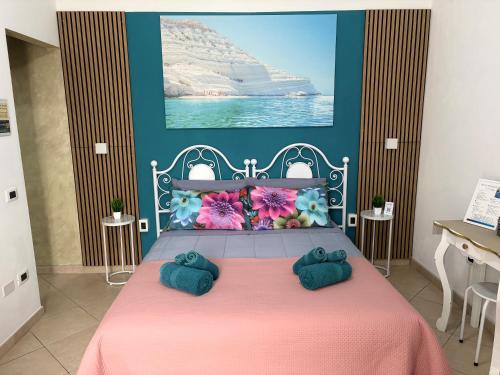 a bedroom with a pink bed with two pillows at M'arriposu in Realmonte