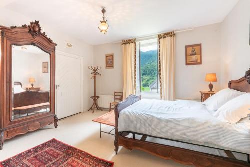 una camera da letto con un grande letto e uno specchio di La Serre a Laborde