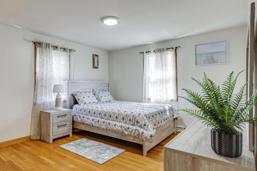 a bedroom with a bed and a potted plant at Walk to Shops & Eats! Attleboro Basecamp in Attleboro