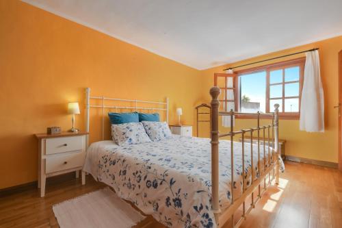 a bedroom with a bed with blue pillows and a window at Villa Casa Concha in Teguise