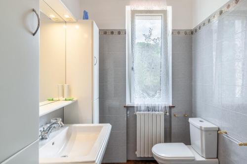 a bathroom with a sink and a toilet and a window at Villa La Lanterna Bianca a Bagnone in Bagnone