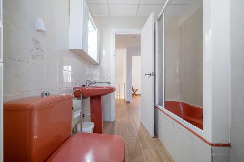 a bathroom with a red toilet and a sink at Villa Amador in L'Ampolla