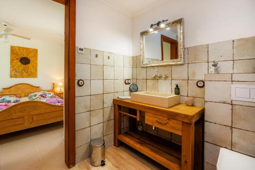 ein Badezimmer mit Waschbecken, Spiegel und Bett in der Unterkunft Finca Soliva in Capdepera