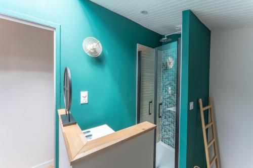 a bathroom with a green wall and a ladder at Villa Rénovée, 5min Plage in Seignosse