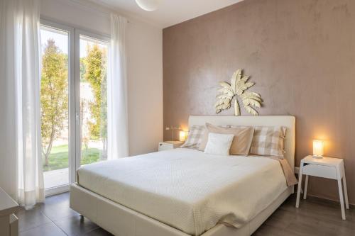 a bedroom with a large bed and a large window at Villa Heraia con piscina in Marina di Ragusa
