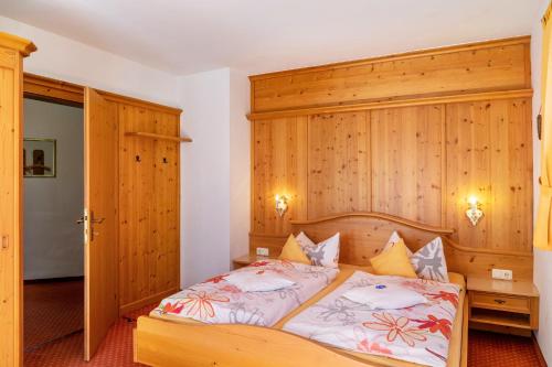 a bedroom with a bed with a wooden headboard at Alpenblick Tilly - Fewo Barmsee 2 in Krün