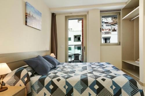 a bedroom with a bed and a window at Albamar 1a in Puerto de Mogán