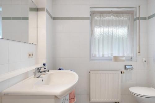 a white bathroom with a sink and a toilet at Grundhof Christian Faller in Rohr
