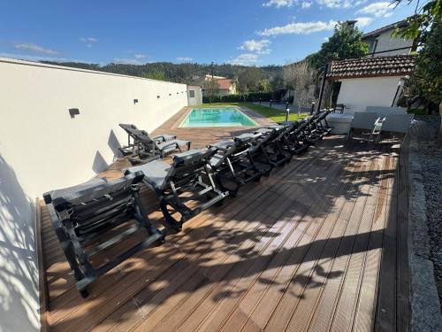 a row of benches sitting on a deck next to a pool at Santa Baia in Veiga