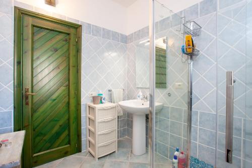 a bathroom with a green door and a sink at Casa Francesco in Orosei