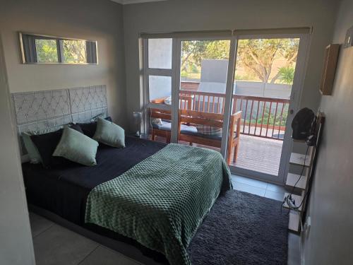 a bedroom with a bed with a view of a balcony at 35 Amanda - Durbanville in Cape Town
