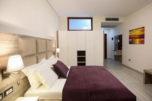 a bedroom with a bed and a tv on the wall at Hotel VD Roleks in Vlorë