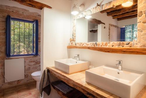 a bathroom with two sinks and a toilet at Casa can Pep Martí in Sant Francesc Xavier