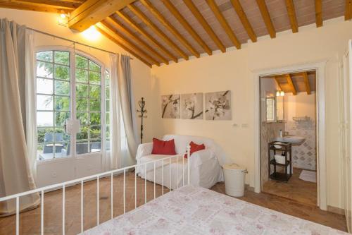 a living room with a white couch and a window at Villa Cava Alta in Riparbella