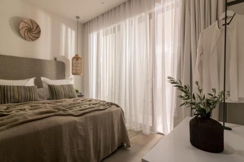 a bedroom with a bed and a large window at Cossoro Cave Villa in Vasilikos