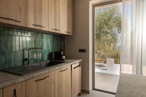 a kitchen with a sink and a large window at Cossoro Cave Villa in Vasilikos