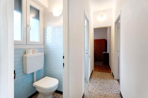 a bathroom with a white toilet and a window at Casa Elsa in Cannobio