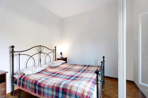 a bedroom with a bed with a plaid blanket at Casa Elsa in Cannobio