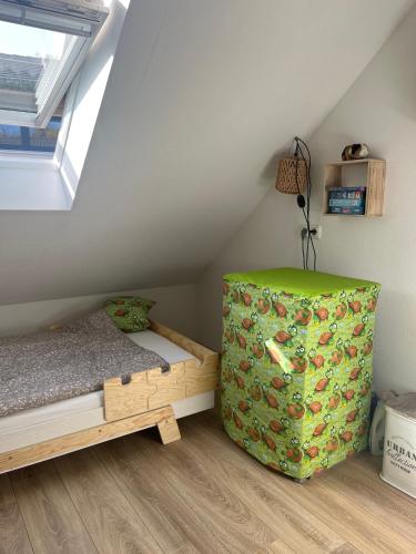 a small attic bedroom with a bed and a window at Plätzchen am Krebsberg in Simmerath