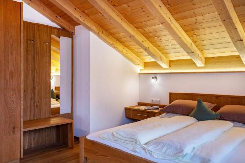 a bedroom with a bed and a wooden ceiling at Feldererhof Gsies Apt Almenblick in Valle Di Casies