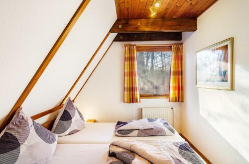 a bed in a small room with a window at Twistesee Ferienhaus 36 in Bad Arolsen