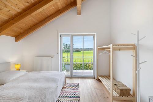 a white bedroom with a bed and a balcony at Appartement Monte Fiori in Anzing