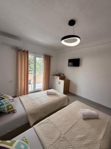 a bedroom with two beds and a light fixture at Apolana Apartments in Negotino