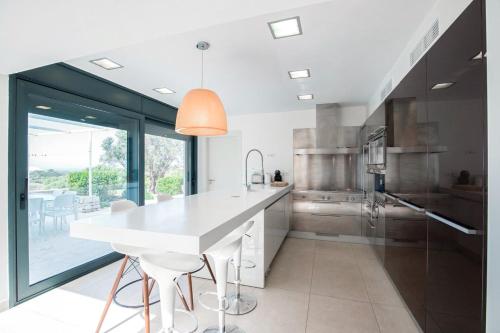 a kitchen with a white counter and a large window at Villa Forma Nou in Mahón