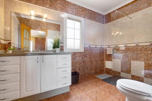 a bathroom with a toilet and a sink and a mirror at Casa Paco 3 in Costa Calma