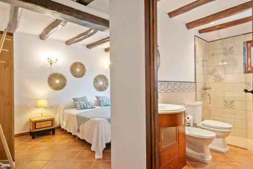a bathroom and a bedroom with a bed and a toilet at Masia Luxmarspa in Tordera