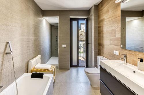 a bathroom with a tub and a toilet and a sink at Casa señorial 14 personas -C. Brava in Palafrugell