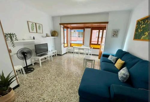 a living room with a blue couch and a television at Hogar dulce hogar. in Águilas
