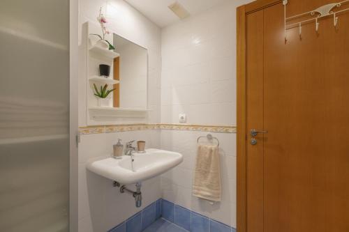 a white bathroom with a sink and a mirror at Bugalú Playa Paraíso in Adeje