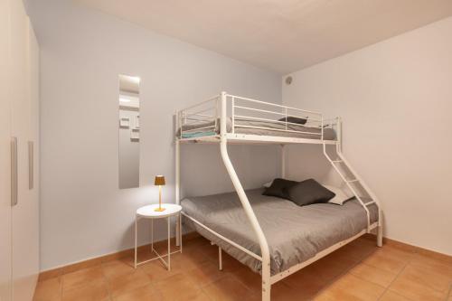 a bunk bed in a white room with a table at Bugalú Playa Paraíso in Adeje