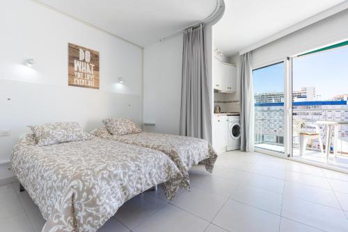 a bedroom with a bed and a large window at Sunny Seaside Studio in Benalmadena Costa
