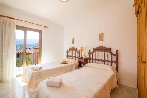 two beds in a room with a window at S'ancora in Port de Soller