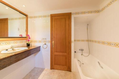 a bathroom with a sink and a tub and a toilet at S'ancora in Port de Soller