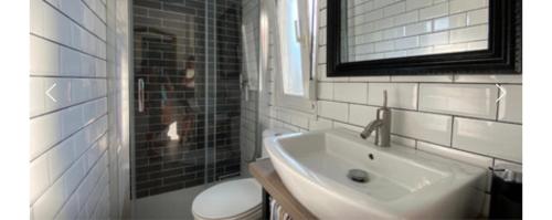 a bathroom with a sink and a toilet and a mirror at Can dennis in Sils