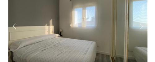 a white bed in a room with a window at Can dennis in Sils