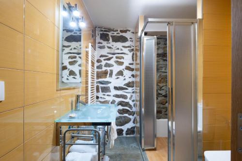 a bathroom with a sink and a stone wall at Casa Do Sil in Monforte de Lemos