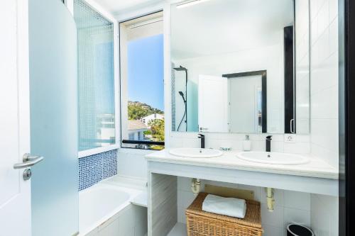a bathroom with two sinks and a window at La Plaza in Port de Pollensa
