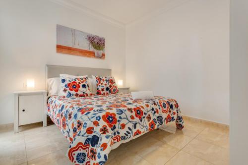 a bedroom with a bed with a colorful comforter at Apartamento Rolycar 102 in Icod de los Vinos