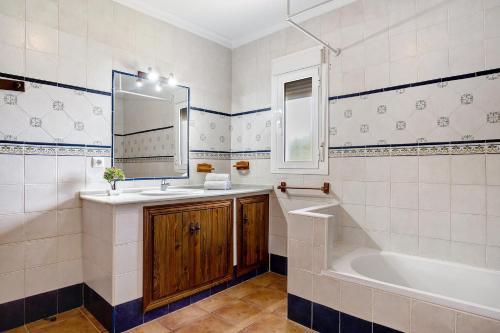 a bathroom with a sink and a tub and a mirror at Casa García in Cádiz