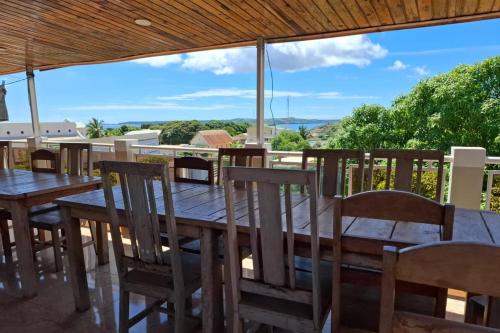 a wooden table and chairs on a patio with a view at Hôtel Concorde in Antsiranana