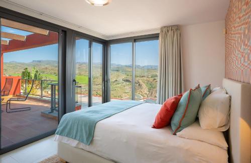 a bedroom with a bed in front of a large window at Las Terrazas Villa 3 in Salobre