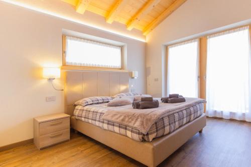a bedroom with a bed and two windows at Appartamento Sant'Antoni Fontana in Livigno
