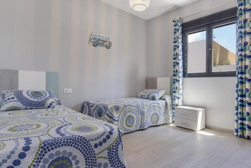 a bedroom with two beds and a window at Casa Toria in Conil de la Frontera